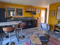 eine Küche mit gelben Wänden sowie einem Tisch und Stühlen in der Unterkunft Les Oucanes in Savines