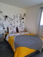 ein Schlafzimmer mit einem Bett mit gelber Decke in der Unterkunft Les Oucanes in Savines