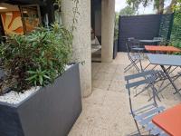 an outdoor patio with tables and chairs and plants at Premiere Classe Quimper in Quimper