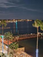 a view of a harbor at night with palm trees at Soleil 2023 in Antibes