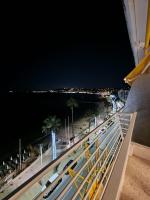 a balcony with a view of a beach at night at Soleil 2023 in Antibes