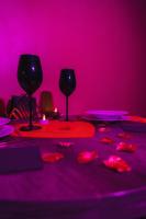 two wine glasses sitting on a table in a pink room at HomeSparadise Loveroom in Besançon