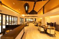 um restaurante com mesas, cadeiras e janelas em H Resort Bohol - The Coral Cliff by SMS Hospitality em Calape