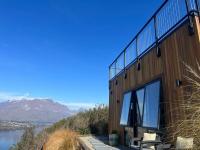 ein Gebäude mit Blick auf das Wasser und die Berge in der Unterkunft Views on Florence in Queenstown
