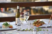a table with two glasses of wine and a plate of food at Hôtel de la jetée in Centuri