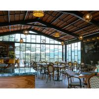 Un restaurante con mesas, sillas y ventanas. en Hotel Casa Xaa, en Tlatlauquitepec