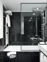 a black and white bathroom with a tub and a sink at The Principal Madrid, Small Luxury Hotels in Madrid