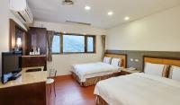 a hotel room with two beds and a desk at Rainbow Resort Hotel in Wenquan