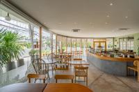 a restaurant with wooden tables and chairs and windows at Fisherman Way Beach Villa in Rawai Beach