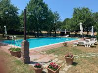 Una piscina con mesa y sillas y flores. en Il Forcone, en Panicale