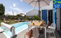 - une terrasse avec une table et un parasol à côté de la piscine dans l&#39;établissement Pierre &amp; Vacances Premium Les Villas d&#39;Olonne, à Les Sables-dʼOlonne