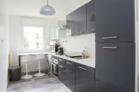 una cocina con armarios grises y encimeras blancas en EXIGEHOME-Beautiful apartment, 2 bedrooms 70m2 15 min from Paris, en Rueil-Malmaison