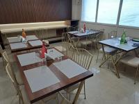 a dining room with tables and chairs with bottles on them at Hotel MK Grand in Varanasi