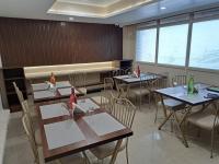 a dining room with tables and chairs and windows at Hotel MK Grand in Varanasi