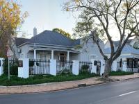 a white house with a black roof and a fence at Just Joey Lodge in Stellenbosch