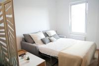 a bedroom with a bed and a couch at Stud confort centre ville 4pers in Saint-Quentin