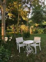 two chairs and a table in the grass at Maison d hôtes Les Chantours dans réserve naturelle 15 hectares in Saint-Antoine-Cumond