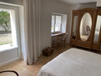 a bedroom with a bed and a desk and a window at Maison d hôtes Les Chantours dans réserve naturelle 15 hectares in Saint-Antoine-Cumond