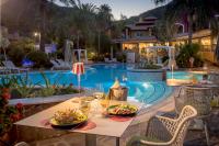 uma mesa com um prato de comida ao lado de uma piscina em Cruccùris Resort - Adults Only em Villasimius