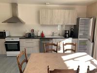 a kitchen with white cabinets and a table and chairs at Gîte du Busatier in Marcillac-la-Croisille