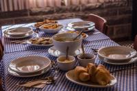 Una mesa con platos y cuencos de comida sobre ella. en Pousada Rugero, en Nova Pádua