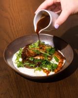 een persoon giet saus over een bord voedsel bij Hutton Hotel in Nashville