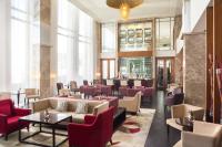 un vestíbulo de un hotel con sillas y mesas rojas en Sheraton Bratislava Hotel, en Bratislava