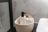 a basket with a bottle of soap and toilet paper at Appartement moderne à 2 pas de la Gare in Toulouse