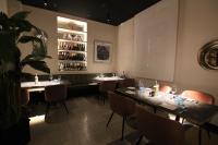 een restaurant met tafels en stoelen en een plank met wijnflessen bij Le Maginot Relais in Castelvetro Piacentino