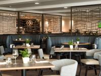 切斯特切斯特希尔顿逸林酒店的一家有桌椅和酒吧的餐厅