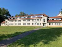 a large white building with a grass field in front of it at Dahlia 107 - zonnig en volledig uitgerust appartement in De Haan
