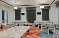 uma sala de jantar com mesas e cadeiras de madeira em Hilton Garden Inn Annapolis em Annapolis