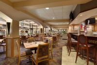 a restaurant with tables and chairs and a bar at Embassy Suites by Hilton Kansas City International Airport in Kansas City