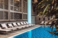 a pool with white chairs and a swimming pool at Hilton Evian Les Bains in Évian-les-Bains