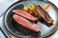 a plate of food with two pieces of meat and potatoes at Hilton Evian Les Bains in Évian-les-Bains