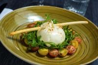 a plate of food with tomatoes and eggs on top at Hilton Evian Les Bains in Évian-les-Bains