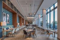 a dining room with tables and chairs and windows at Hilton Evian Les Bains in Évian-les-Bains