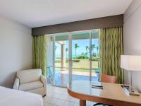 a room with a bed and a desk and a table at Hilton Ponce Golf & Casino Resort in Ponce