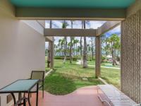 a patio with a table and chairs and palm trees at Hilton Ponce Golf & Casino Resort in Ponce