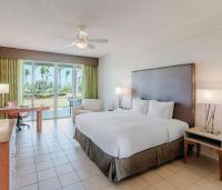 a bedroom with a large bed and a living room at Hilton Ponce Golf & Casino Resort in Ponce