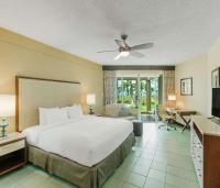 a bedroom with a large bed and a living room at Hilton Ponce Golf & Casino Resort in Ponce