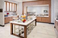 a kitchen with a table with bowls of fruit on it at Hilton Garden Inn Dallas/Arlington South in Arlington