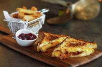 ein Schneidebrett mit einem Sandwich und einem Korb mit Pommes frites in der Unterkunft Hilton Garden Inn Annapolis Downtown in Annapolis
