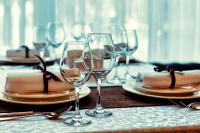 Una mesa con copas de vino y platos encima. en SULTAN PLAZA Borovoe, en Burabay