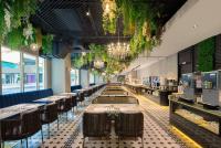 un restaurante con una larga fila de mesas y sillas en TRYP by Wyndham New Taipei Linkou - MRT A9, en Linkou