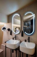 two sinks in a bathroom with two mirrors at Hôtel Riesner in Paris