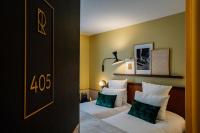 a hotel room with two beds with green pillows at Hôtel Riesner in Paris