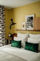 a bedroom with a bed with green and white pillows at Hôtel Riesner in Paris