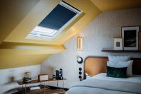 a bedroom with a large bed with a skylight at Hôtel Riesner in Paris