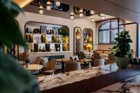 a restaurant with tables and chairs and a window at Hôtel Riesner in Paris